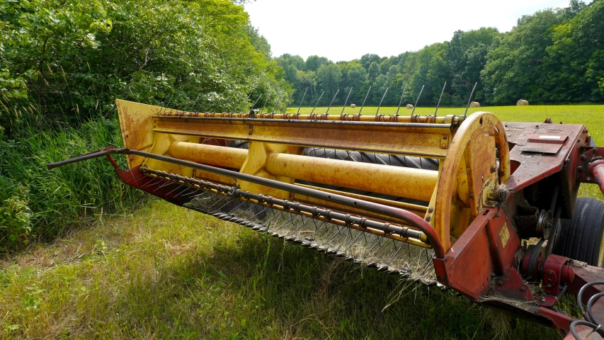 a yellow machine is on a grassy field