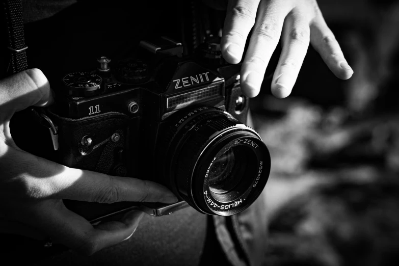 hands hold a camera in black and white