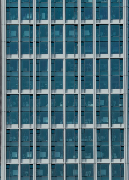 the large windows on a tall building are reflecting each other