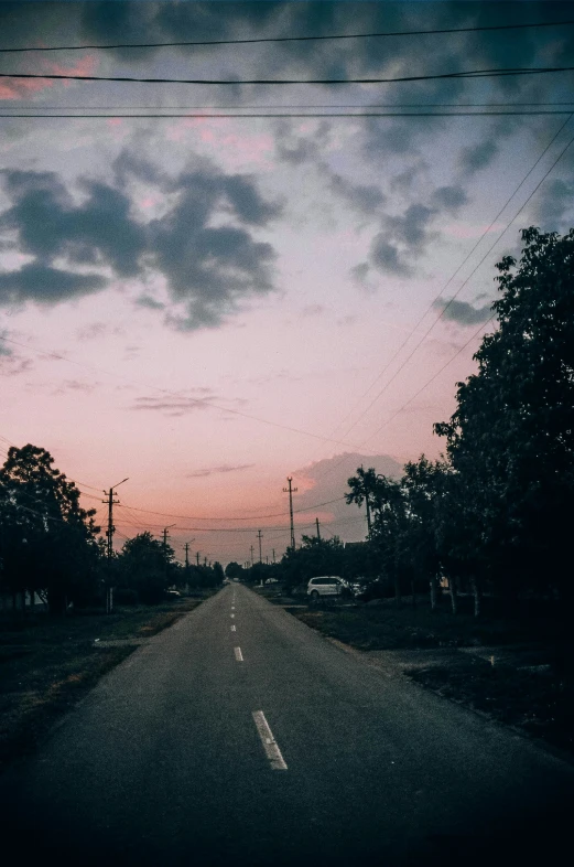 the sky is dark and cloudy but not so far from the road