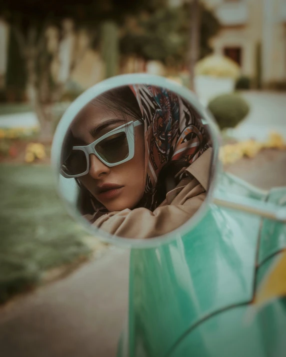 a woman's reflection in a car's side mirror