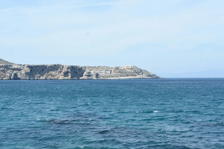 a boat is sailing through the water near a large island