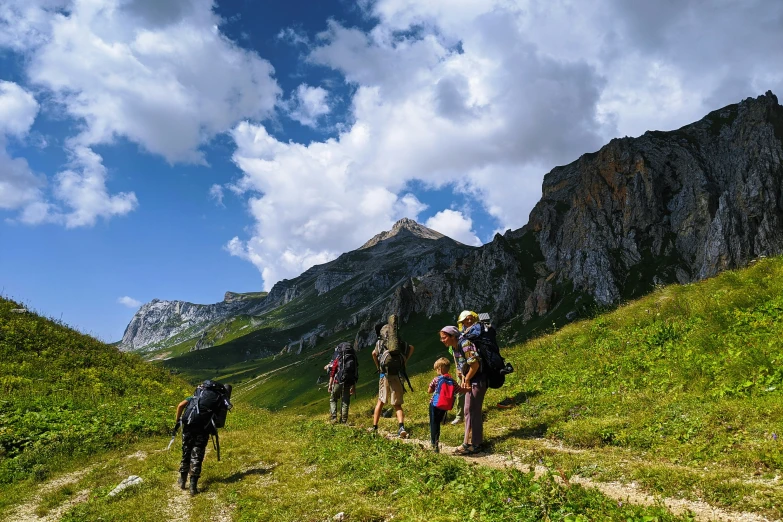 several people walking down a path in a grassy field