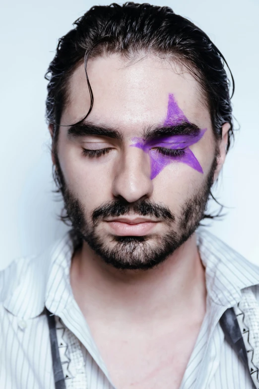 the bearded man has some purple eyeliner