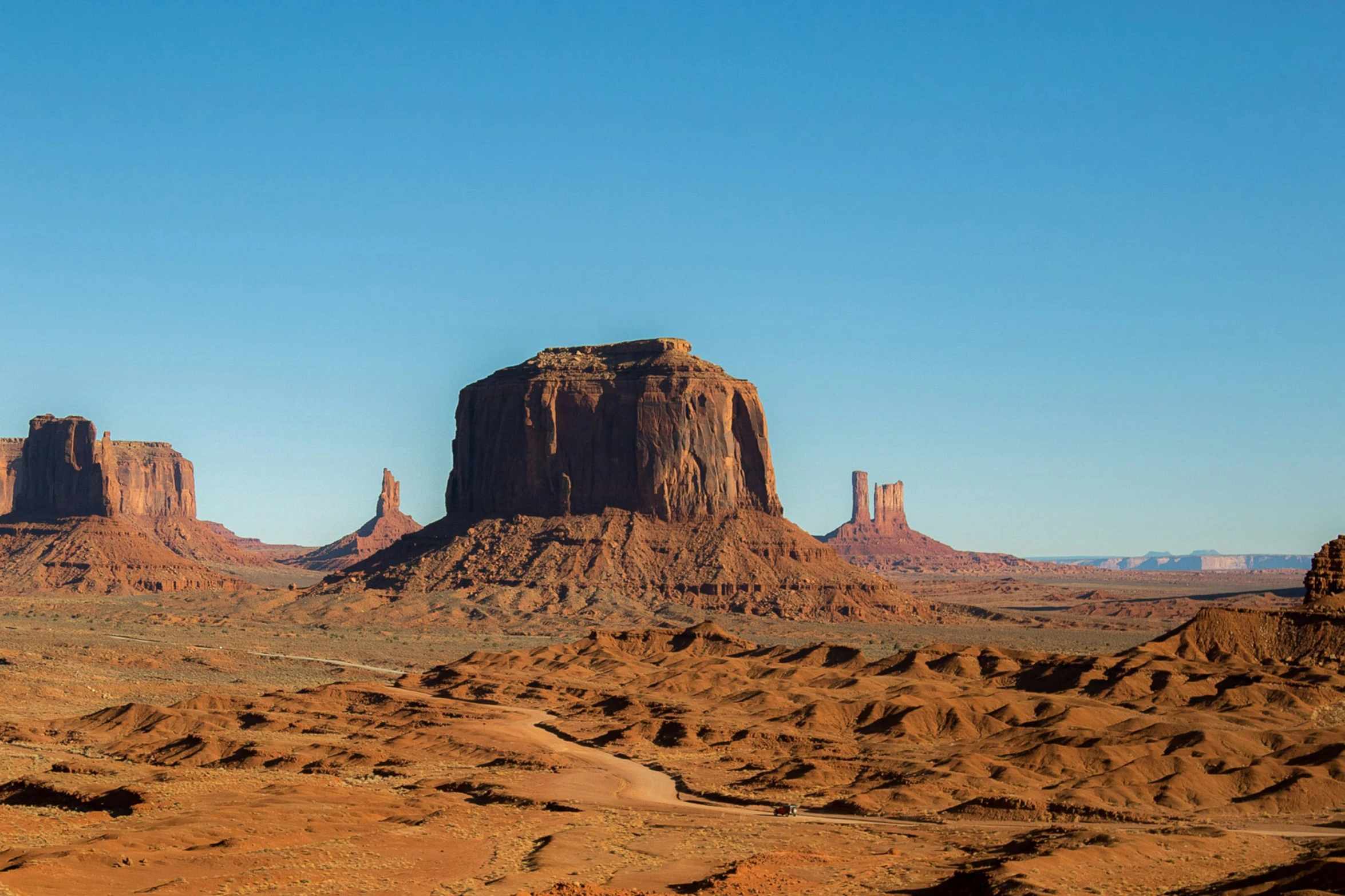 two large rocks in a desert under a blue sky