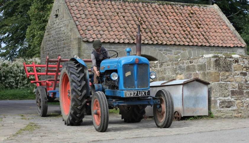 a man standing on top of a large blue tractor