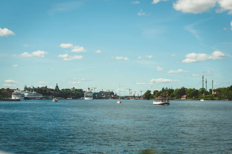 a view from the shore of some water with boats and ships sailing by