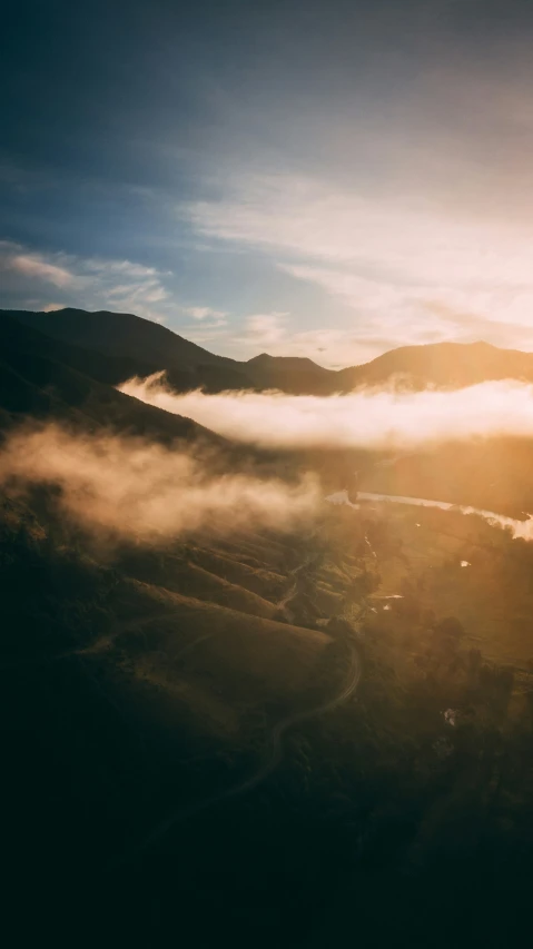 the sun peeking through some cloud in the distance