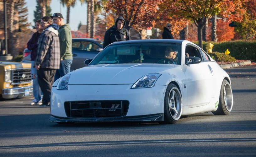 a white sports car driving down a street