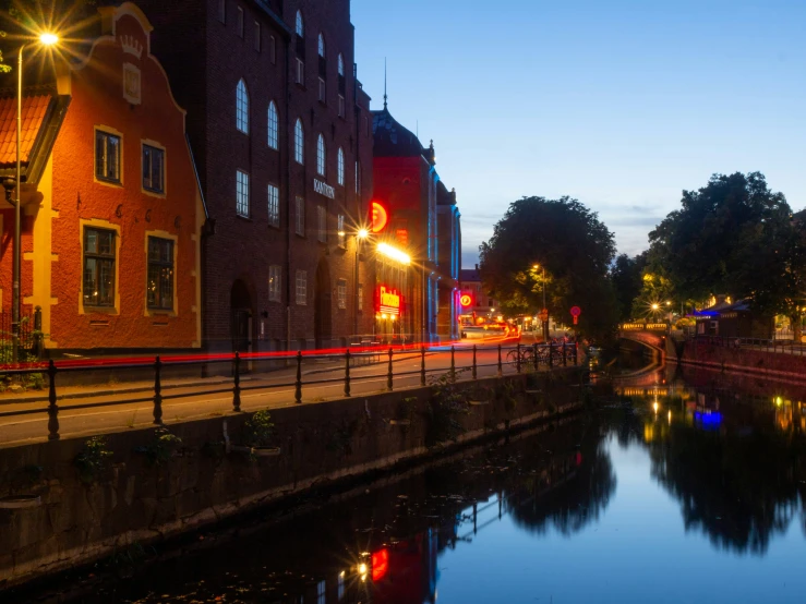 a river flowing under a bridge near a tall brick building