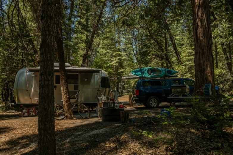 a rv parked in the woods with its roof propped up