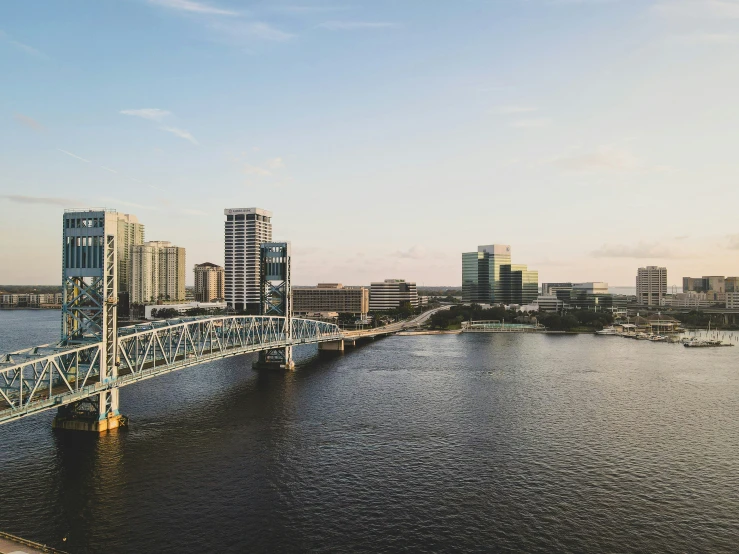 the skyline is reflected in the water next to the bridge