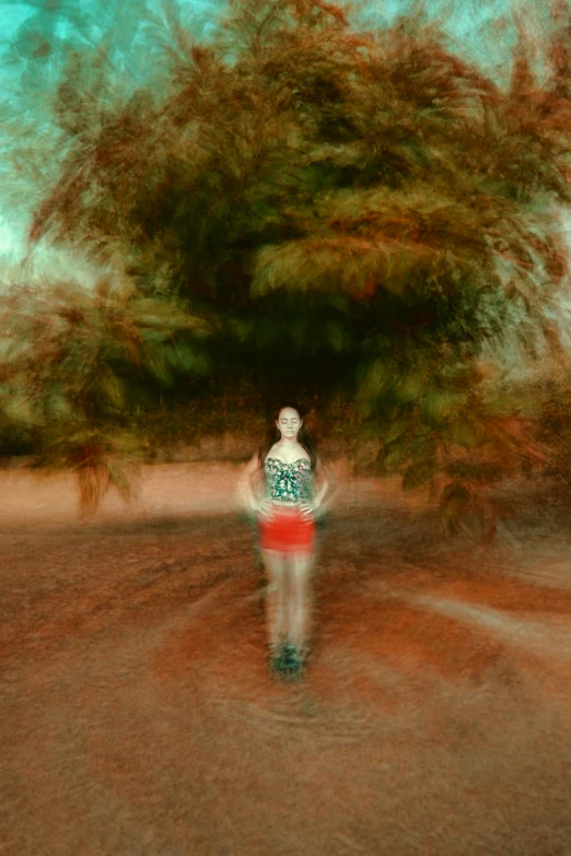 blurry image of a woman walking down the street in front of a tree