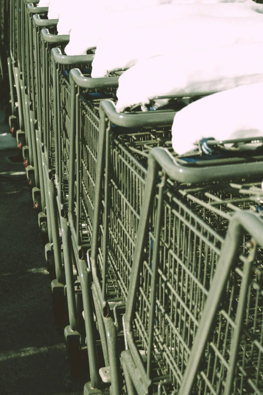 shopping carts parked on the sidewalk covered in snow