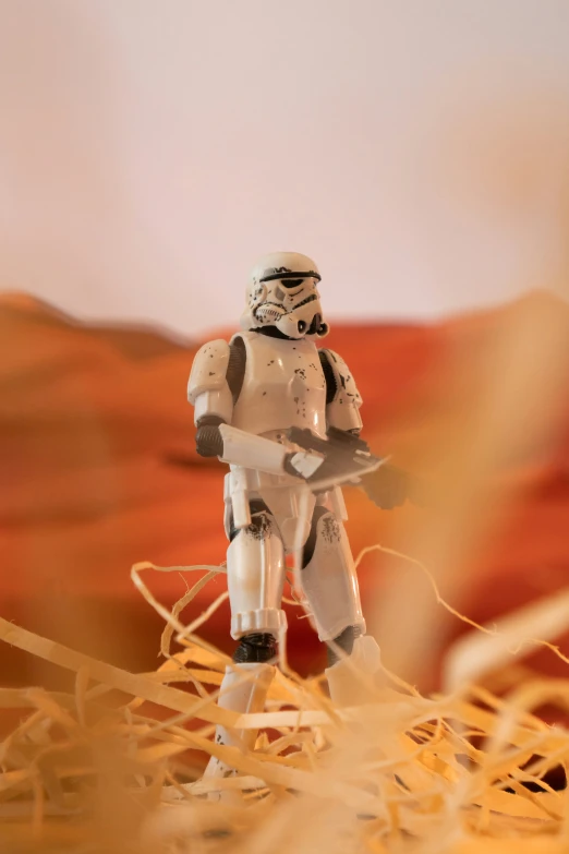 a star wars figure stands on a desert floor