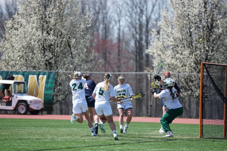 a group of female lacrosse players run on the field