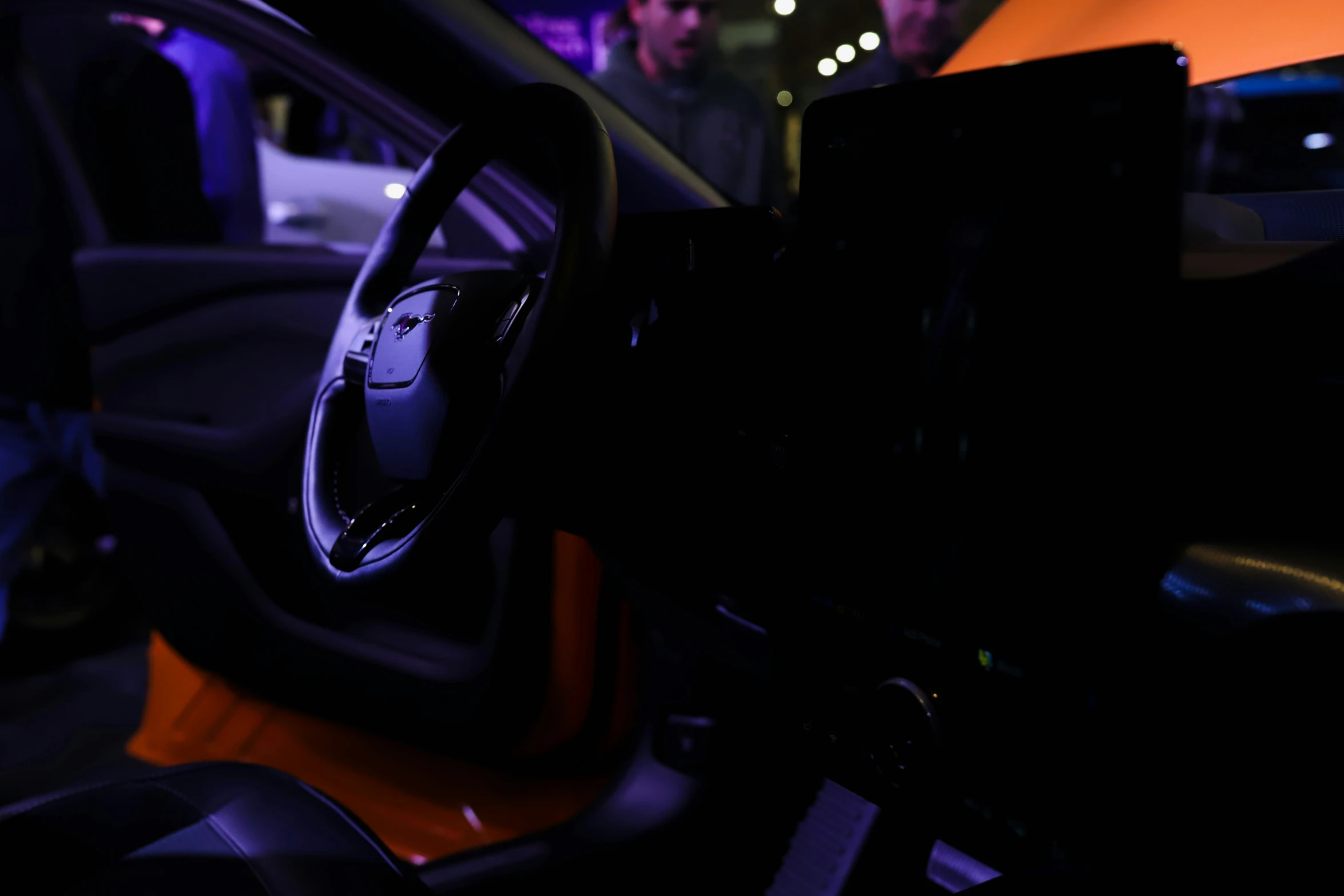 the dashboard of a car with people in the background