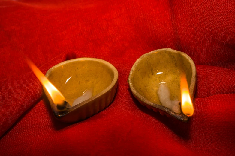 two clay bowls that have light sticks in them