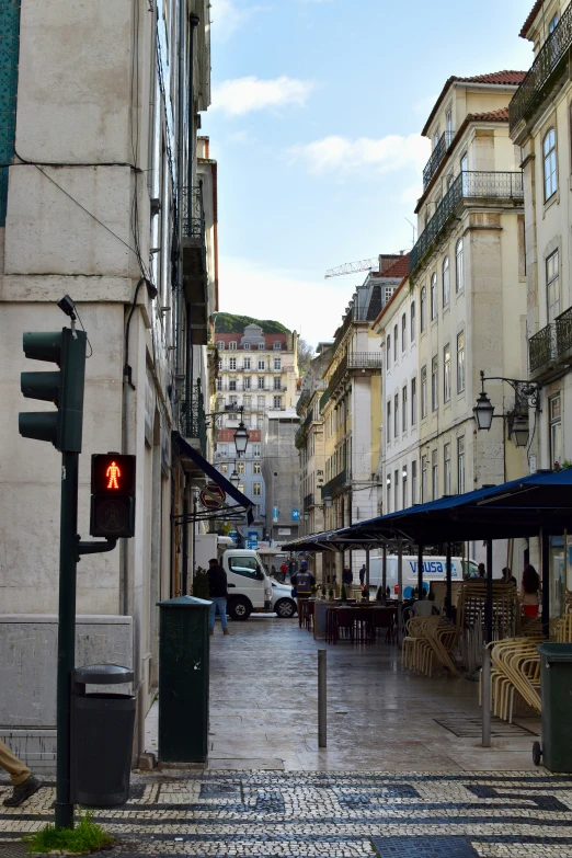 city area with parked vehicles and a red traffic light