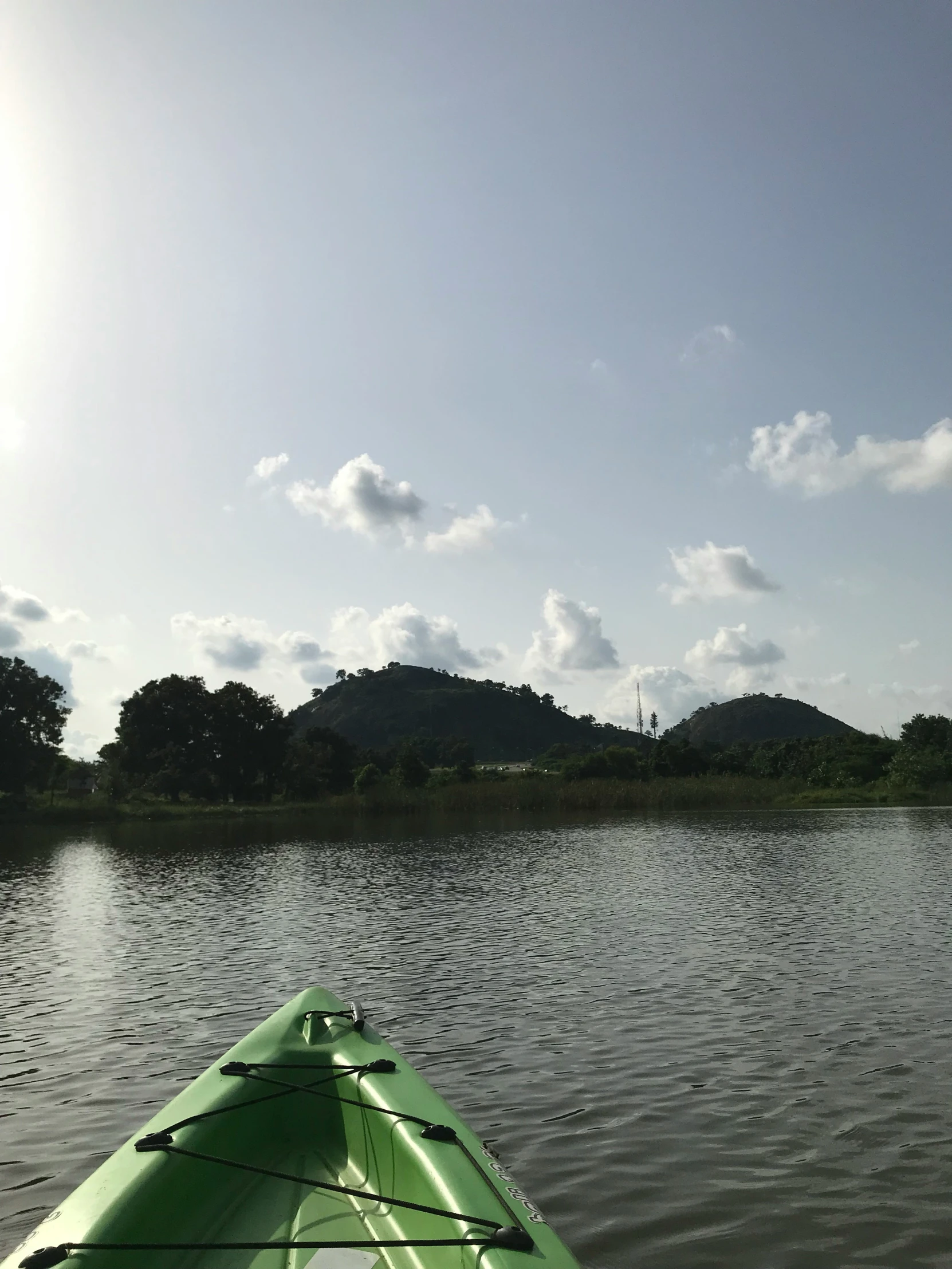 the side view of a kayak in calm water with mountains behind it