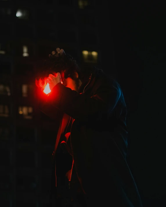 a man is holding his hand with a bright light in the dark