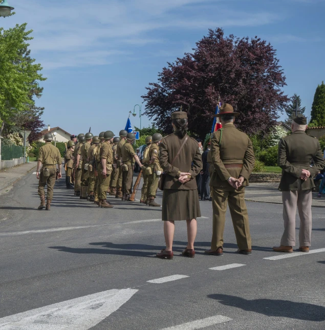 a group of soldiers stand together while one person dressed in brown and other people in brown are standing in front of them