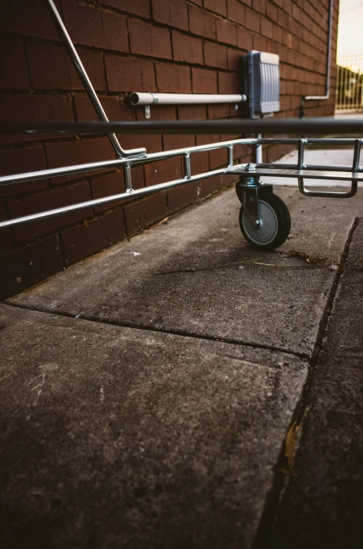 a pair of wheels on a railing near a brick wall