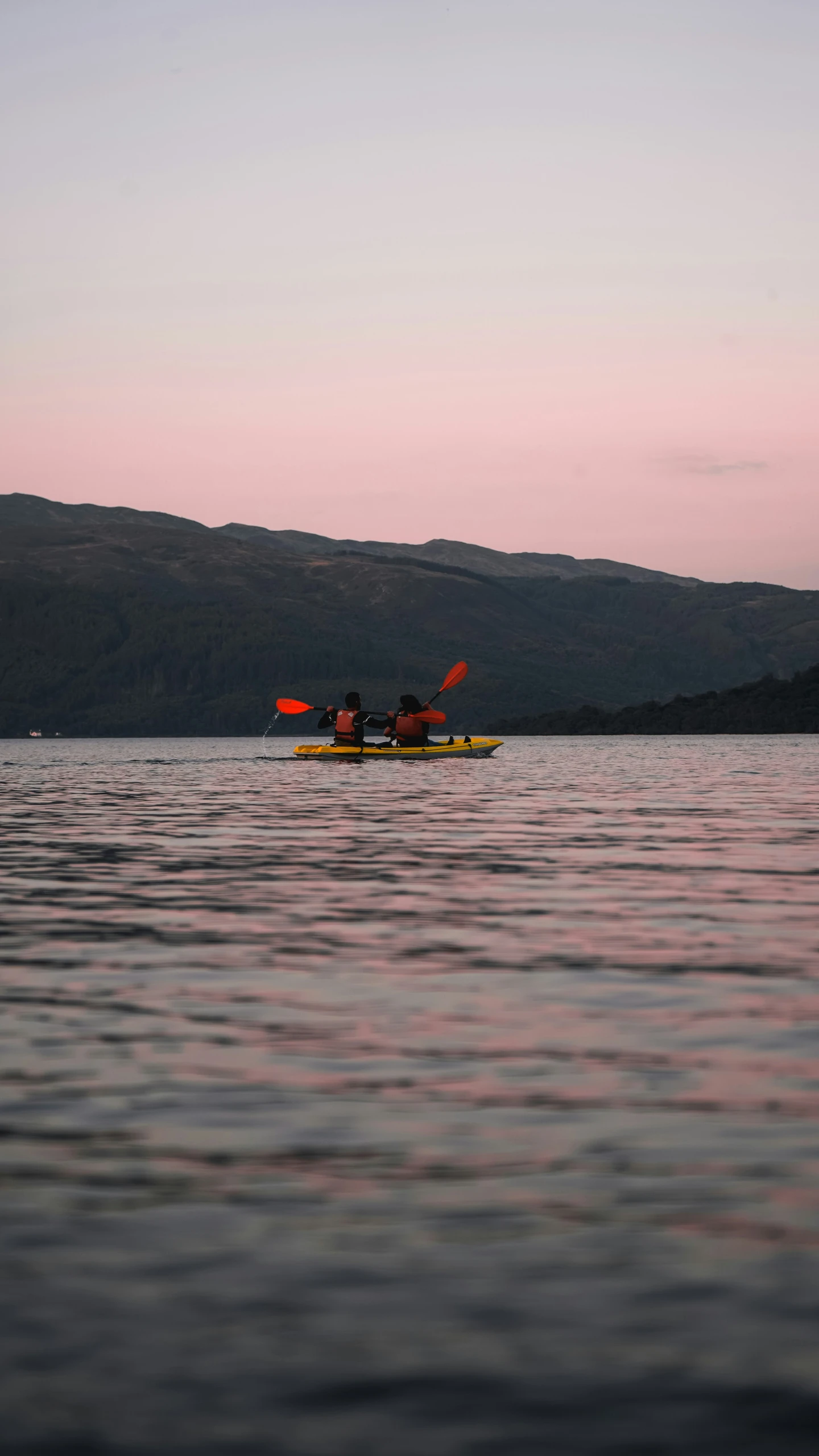 two people on kayaks paddling down a large body of water