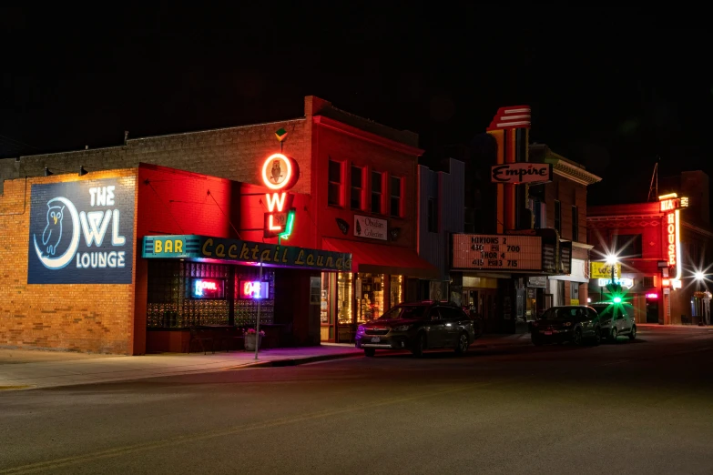 a street scene at night with cars and buildings lit up