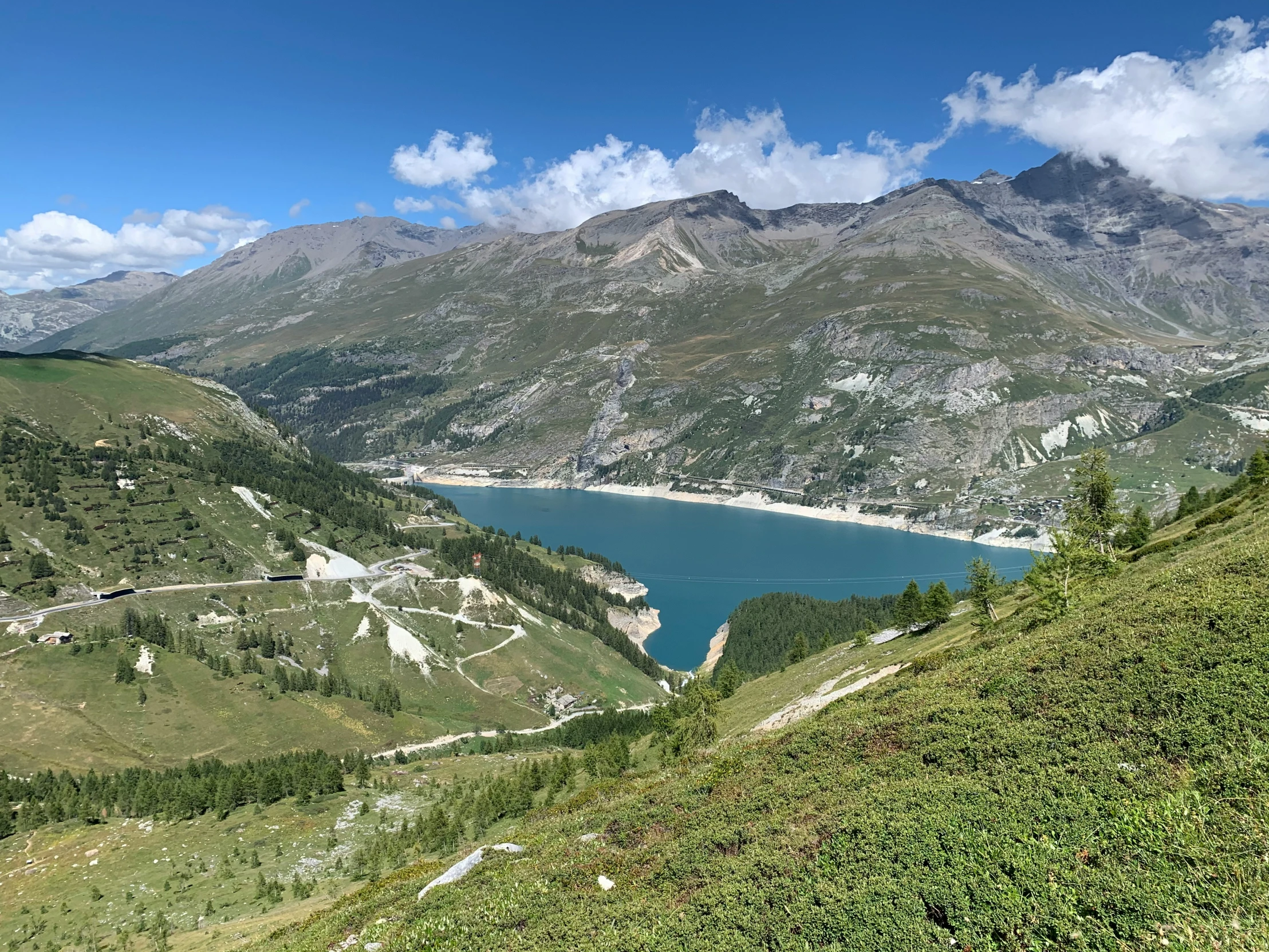 a green mountain has a lake in it