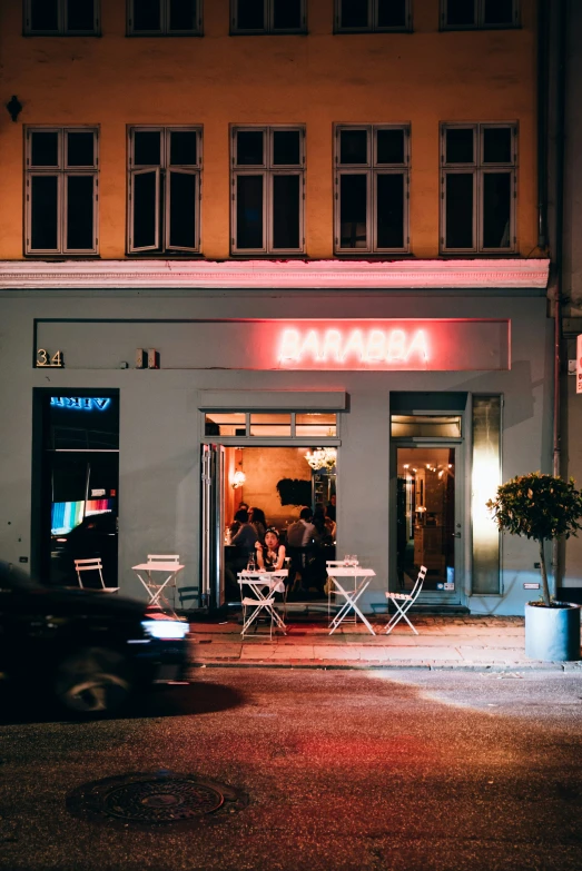 a couple sit at a table outside of a building