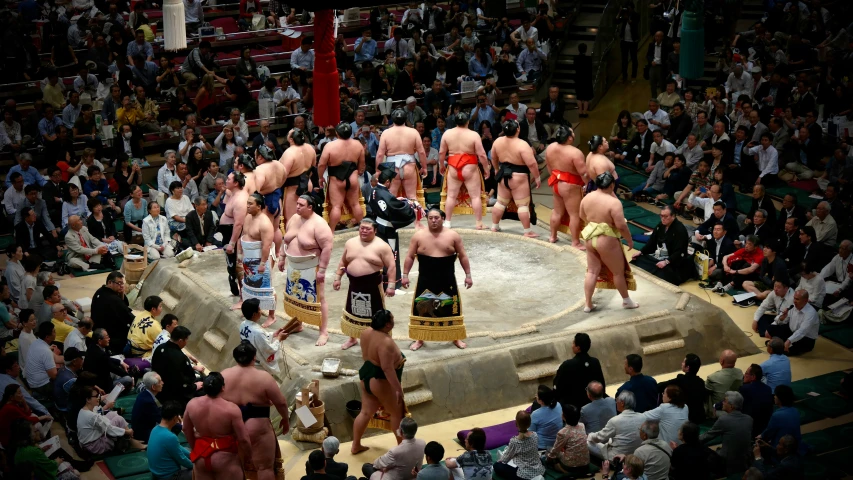 men in different wrestling uniforms perform on an outdoor ring