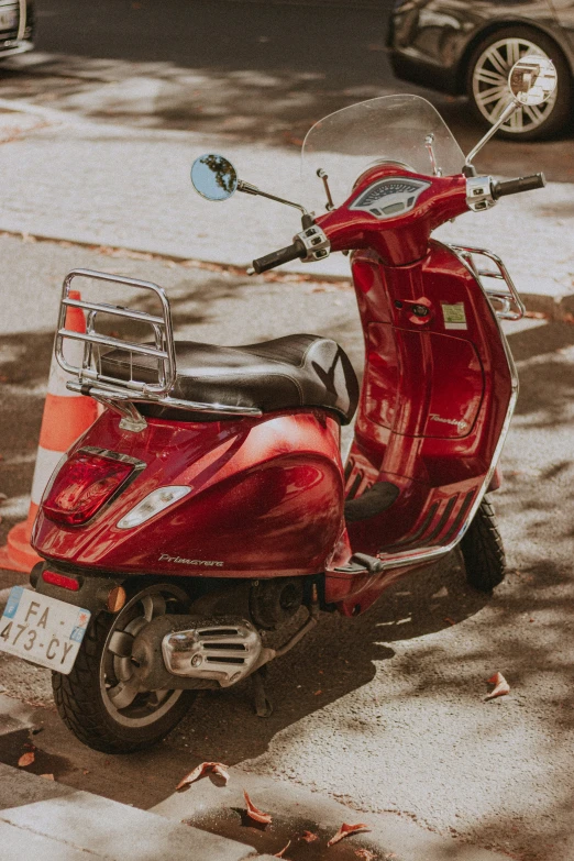 red moped parked in a parking spot on a sidewalk