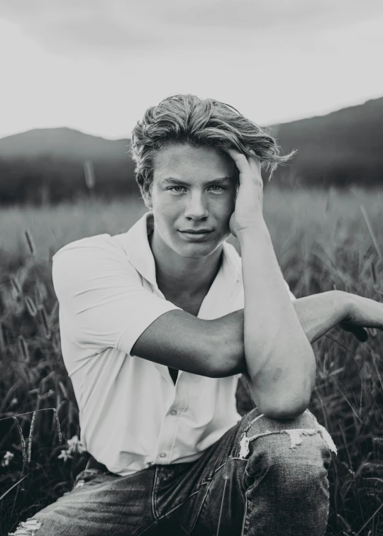 black and white pograph of a young man in a grassy field