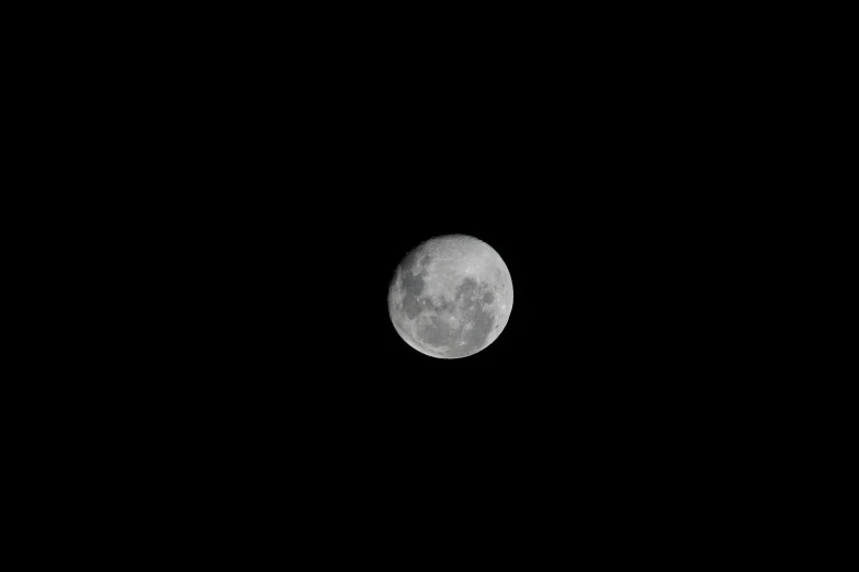 an airplane flying over the moon on a night sky