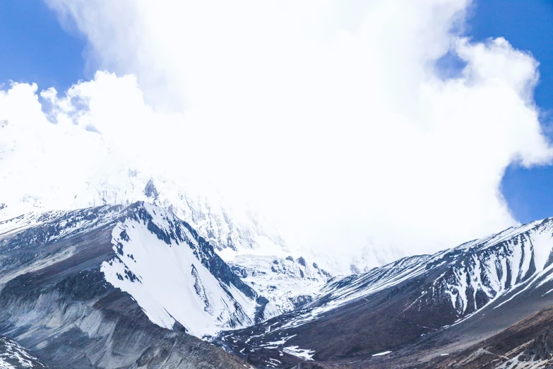 a snow covered mountain side with the sky above