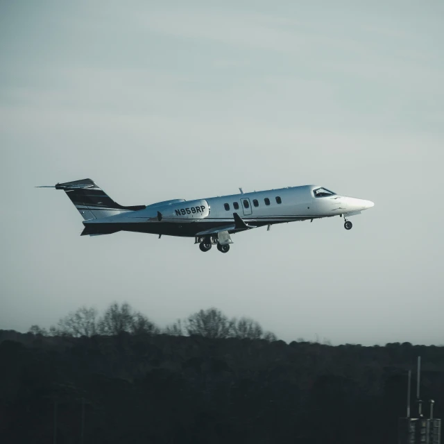 a white plane is flying low to the ground