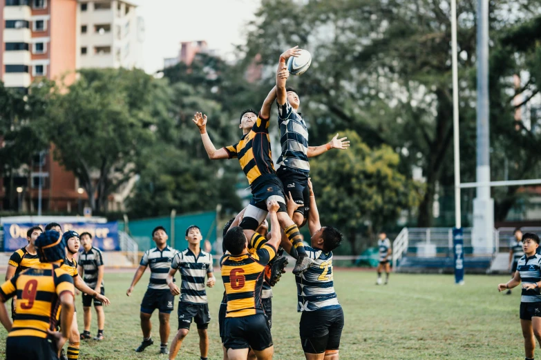 group of people playing a game of rugby in a field