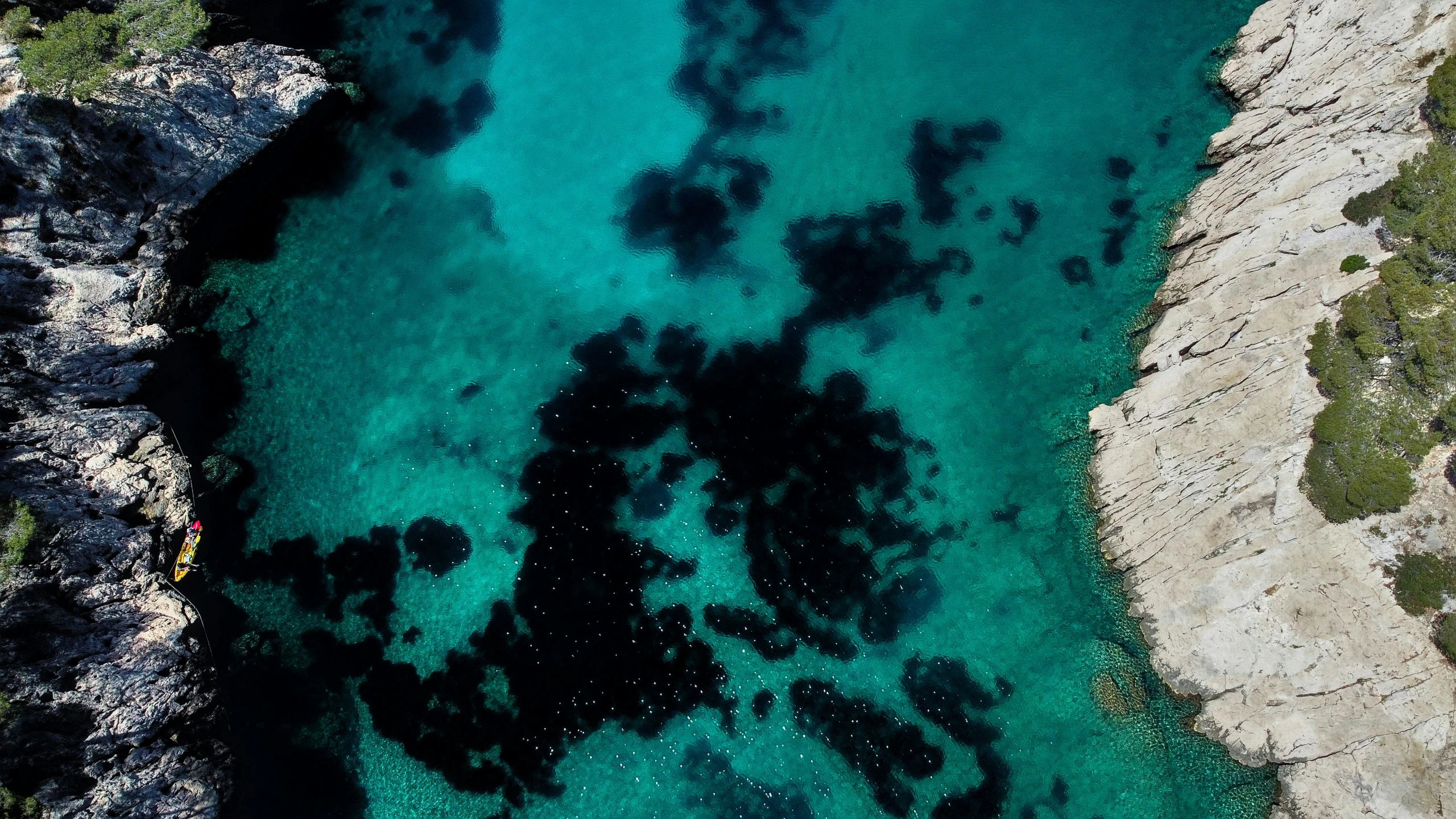 some green water is surrounded by rocky shore