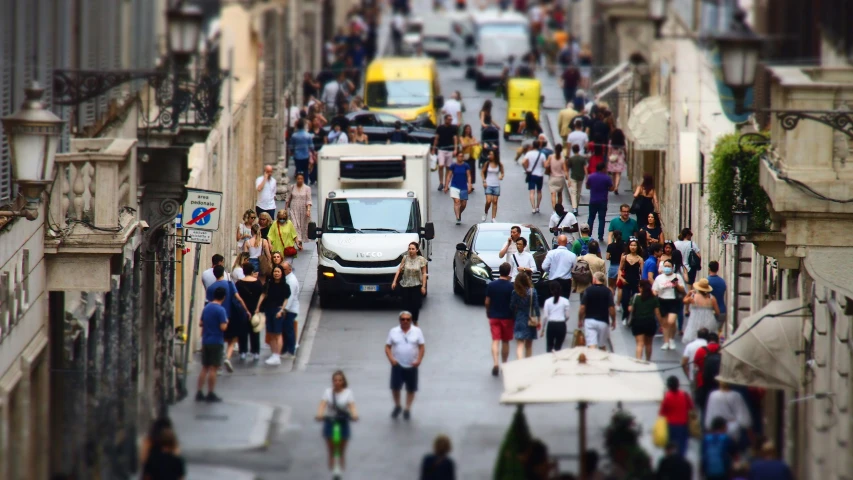 a street full of people and a bus going down it