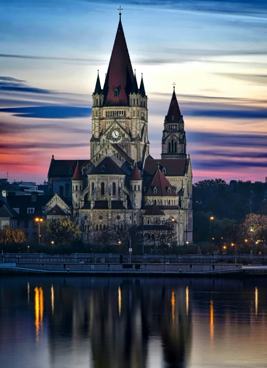 a tall building sitting on top of a lake next to a forest