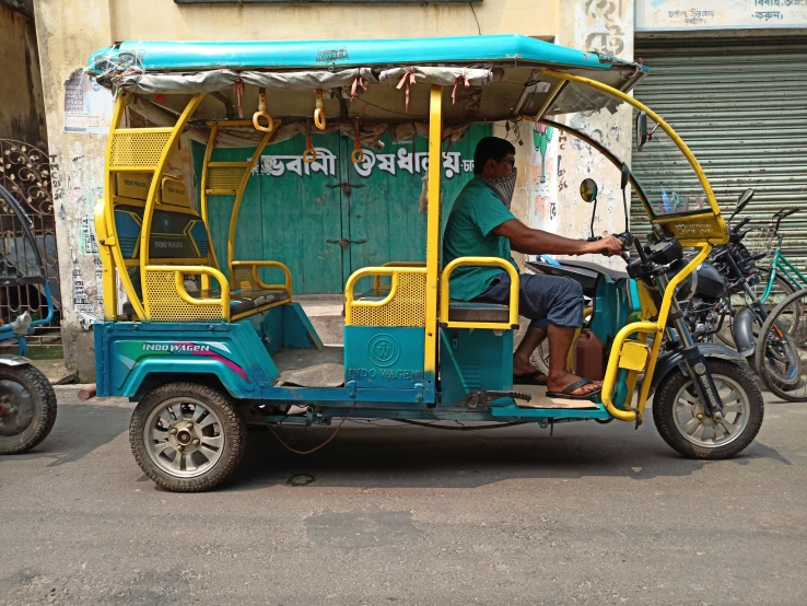 a man drives an auto rickshaw with passengers