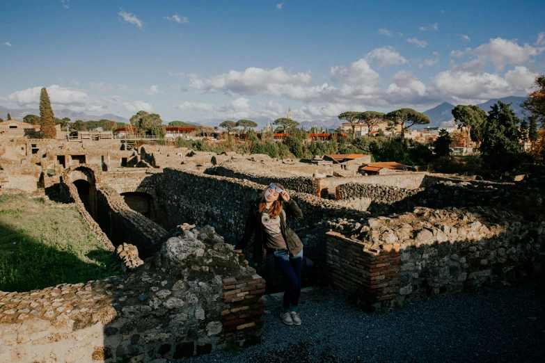 a person standing outside next to old brick structures