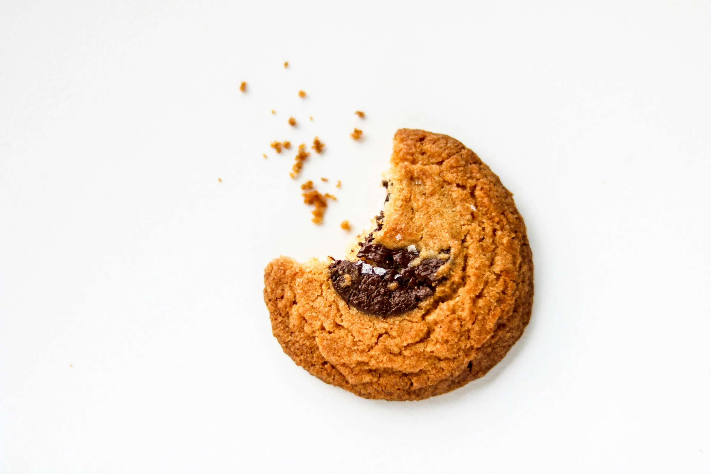 half eaten chocolate chip cookie on a white background