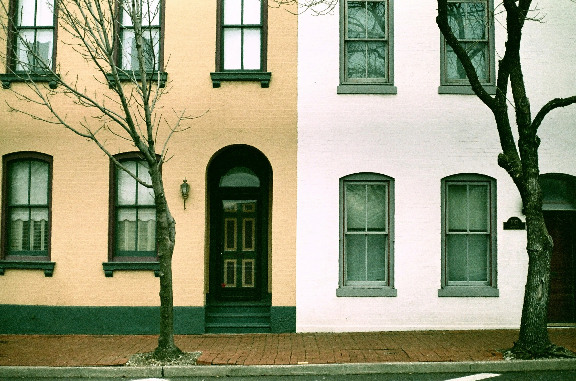 two identical houses next to each other with different windows