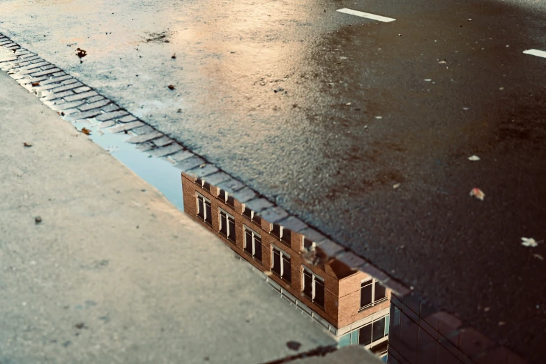 a building has rain in front of it, while another is out on the sidewalk