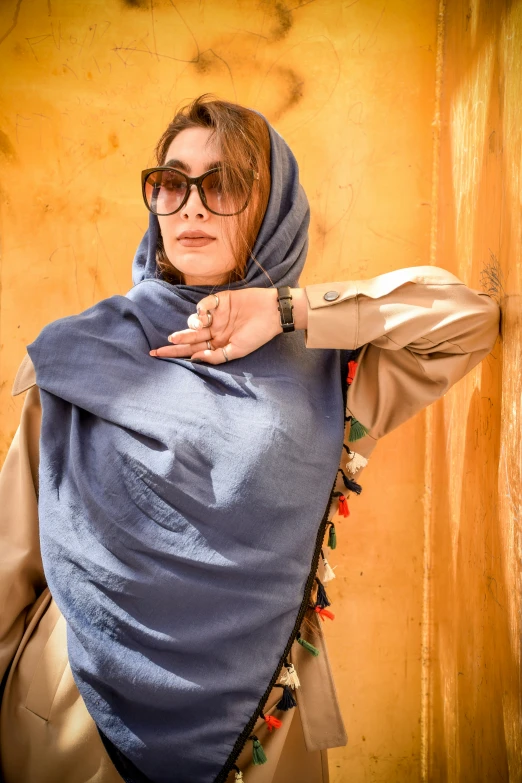 a woman in sunglasses and shawl posing