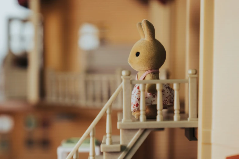 there is a little stuffed rabbit standing on a balcony