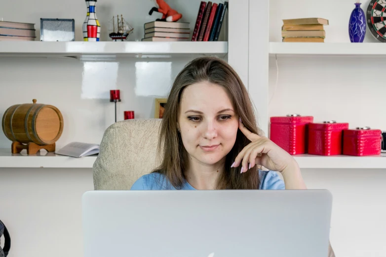 the girl is looking at the laptop screen