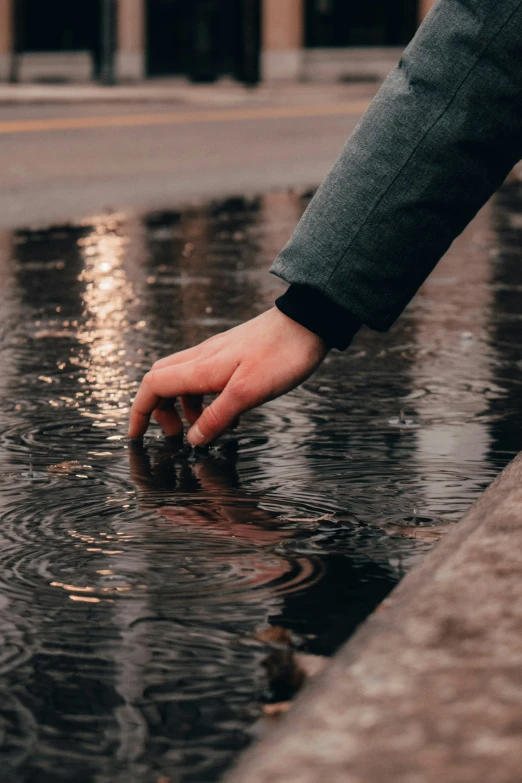 a person reaching to get into the water